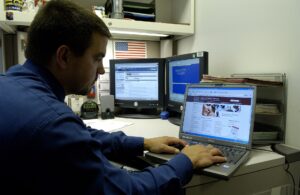 A person using a laptop at a desk to plan and book travel