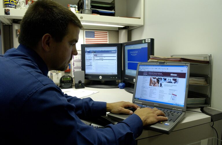 A person using a laptop at a desk to plan and book travel