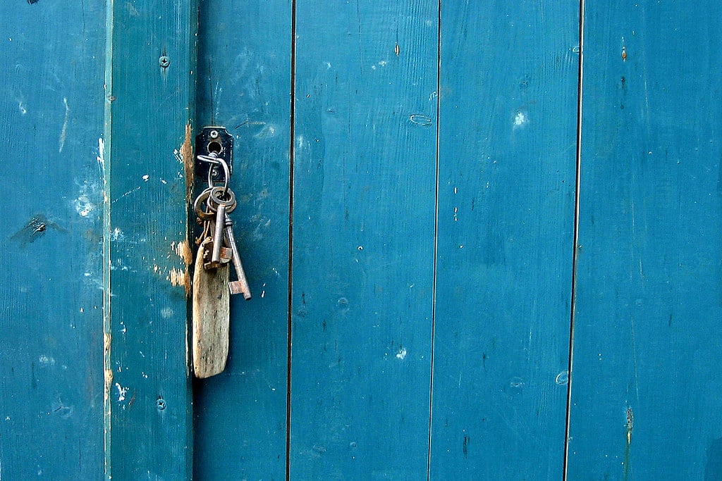 A set of house keys in the lock of a front door