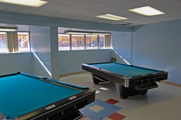 A home game room with a full-size pool table set up for play